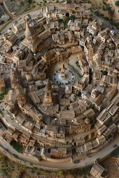 an aerial view of a city with lots of buildings and trees in the middle of it