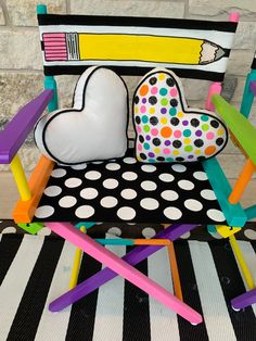 a colorful chair with a heart shaped pillow on the seat and some colored pencils