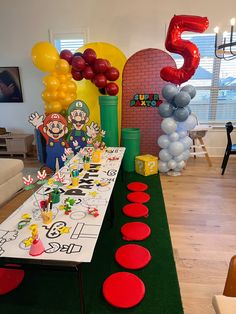 a birthday party with balloons and decorations in the shape of numbers on a long table