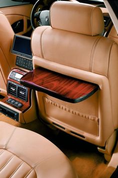 the interior of a luxury car with wood trim