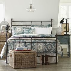 a bed room with a neatly made bed and baskets