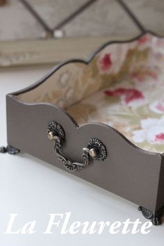 a close up of a tray on a table with flowers in the background and an ornate design