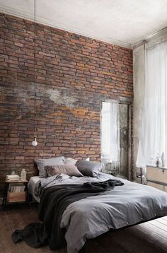 a bedroom with brick walls and a large bed