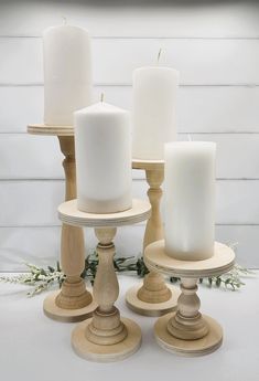 four white candles sitting on top of each other