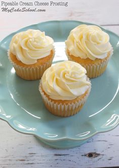 three cupcakes with white frosting on a blue plate