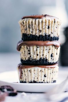 three cupcakes stacked on top of each other with chocolate frosting and oreo cookies