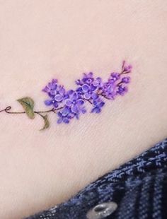 a small tattoo with purple flowers on it