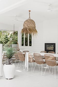 an outdoor dining area with chairs, table and potted plant