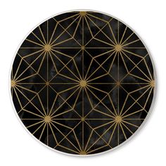 a black and gold plate with geometric designs on it, in the shape of a circle