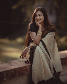 a woman sitting on top of a brick wall