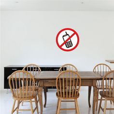 a table with chairs and a no cell phone sign on the wall in front of it