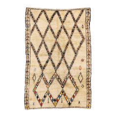 an antique afghan rug with diamond design on the front and sides, in cream color