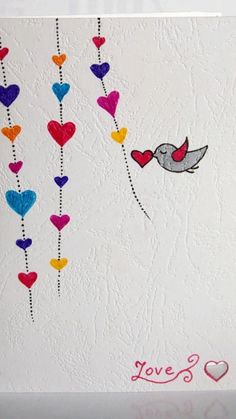 a white card with hearts and a bird on the string that says love's