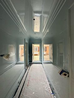 an empty room with white walls and flooring in the process of remodeling