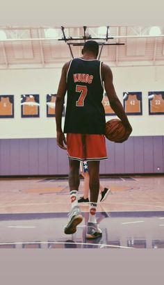 a man holding a basketball on top of a basketball court