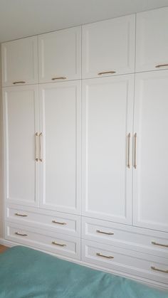 a bedroom with white cabinets and blue sheets