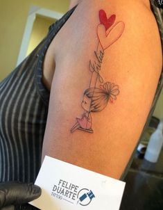 a woman with a tattoo on her arm holding a heart shaped balloon in the air