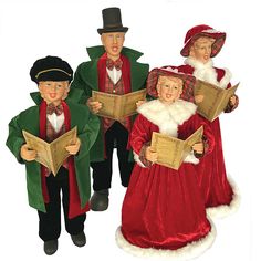 three figurines are dressed in christmas costumes