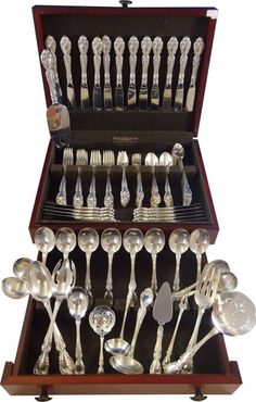 an assortment of silverware in a wooden box