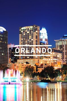 the city skyline is lit up at night with lights reflecting in the water and fountains