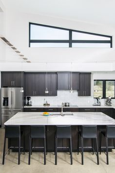 a large kitchen with an island and stainless steel appliances