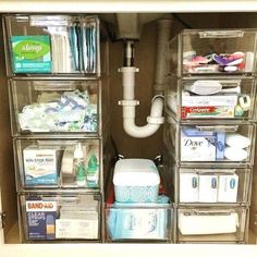 the inside of a closet with clear drawers and plastic bins filled with toiletries