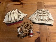 two wooden model boats sitting on top of a wooden table