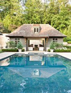 an outdoor swimming pool in front of a house