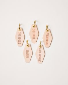 four pink tags with the words coffee and smile on them, hanging from gold hooks