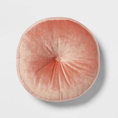 an orange round cushion on a white surface