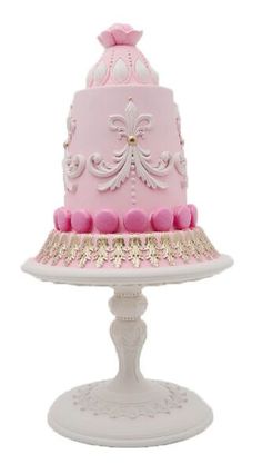 a pink and white cake sitting on top of a table