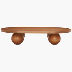 an oval wooden table with two balls on the top and one ball at the bottom