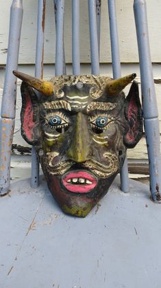 a mask sitting on top of a metal chair