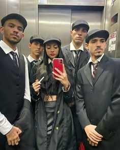 a group of men and women taking a selfie in an elevator with their cell phones