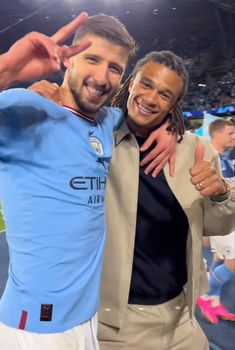 two men standing next to each other at a soccer game