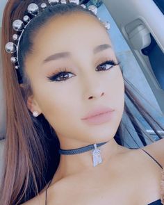 a woman wearing a choker and pearls on her head is posing for the camera