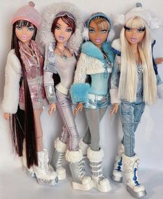 three dolls are standing next to each other in front of a white background and one is wearing skis