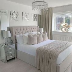 a bedroom with a large bed and chandelier