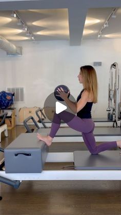 a woman is doing exercises on an exercise bench with a ball in her hand while another person watches from the other side