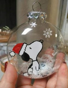 a person holding a glass ornament with a dog on it