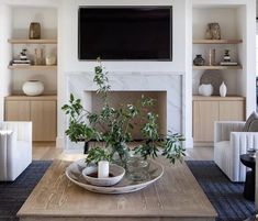 a living room filled with furniture and a flat screen tv mounted above a fire place