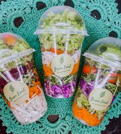 three plastic containers filled with different types of salads on a doily next to a crocheted place mat