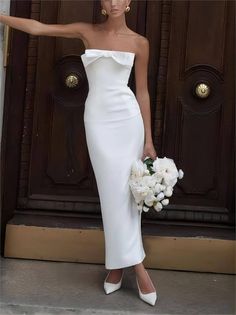 a woman in a white dress holding flowers