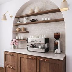 a coffee machine sitting on top of a counter next to a wall with shelves above it