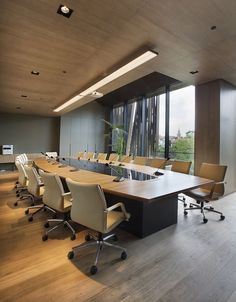 an empty conference room with wooden floors and large windows