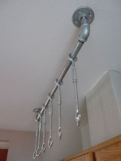 an overhead view of some kitchen utensils hanging from the ceiling in front of cabinets