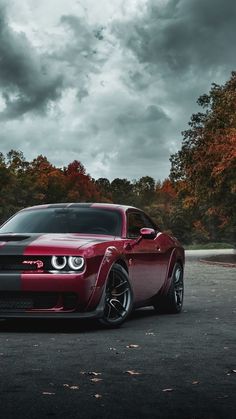 a red sports car parked in front of some trees