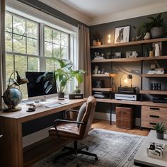 a home office with a desk, chair and bookshelf in front of a large window