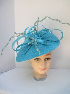 "* This design can be worn on either side of the head and has a sophisticated side tilt. It features a monocromatic color scheme in a tantalizing turquoise. The center of the hat form has a burst of looped and swirled braiding accented by enhanced clusters of matching berries and curly berry twigs. * On an 12\" round flat hat form this is a great design for spring and summer and will also go right into the fall and winter as well. * It is light weight, balanced and comfortable on a white satin c Hat Form, Flat Hat, Ladies Luncheon, Easter Hats, Tweed Suit, Flat Hats, Metal Headbands, Charity Event, Costume Hats