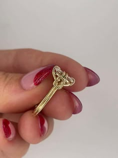 a woman's hand holding a gold key ring